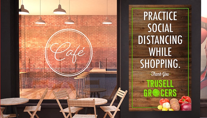 Large social distancing poster outside of a grocery store and cafe